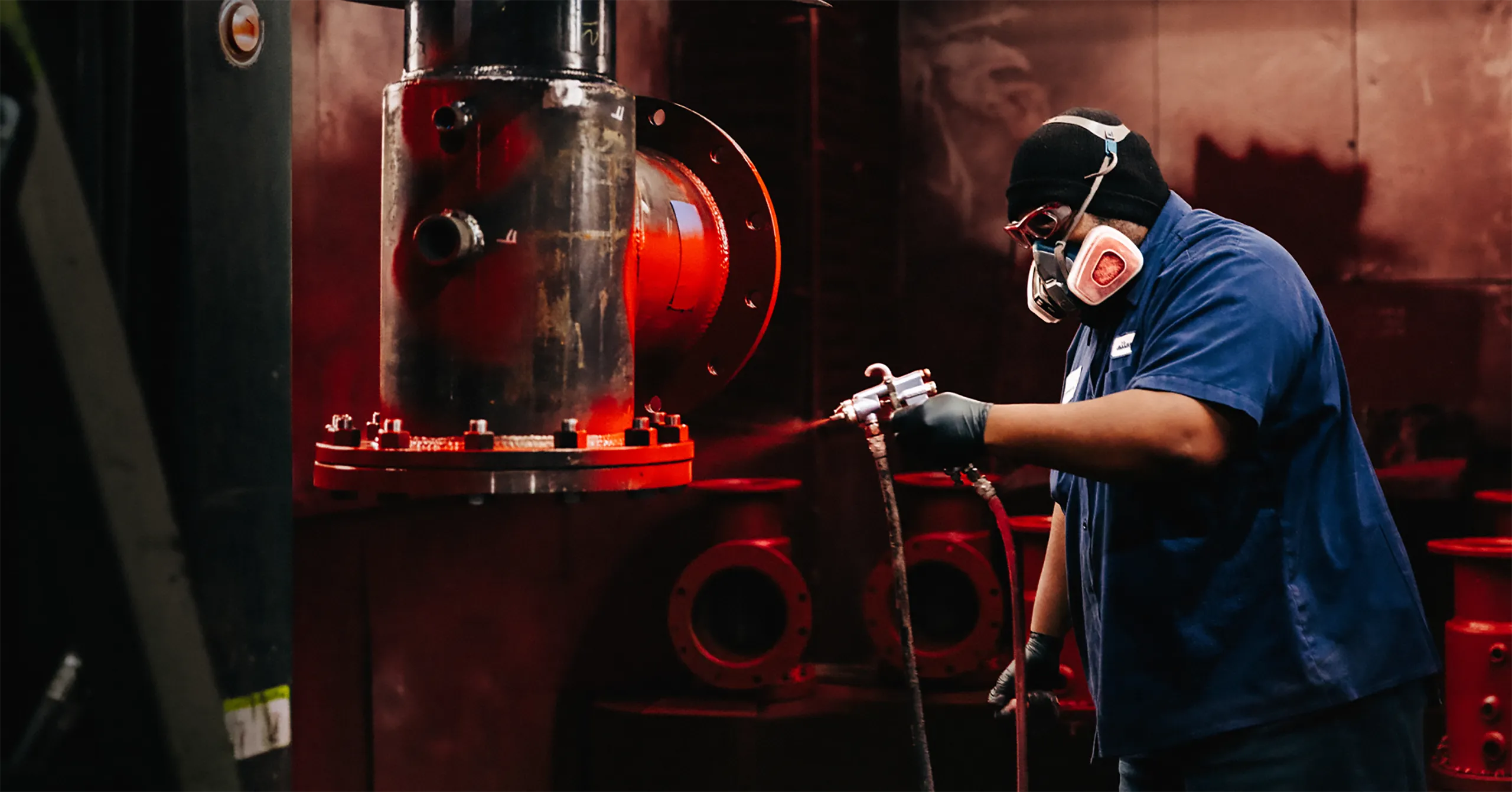 American Wheatley master painter applying finish to a large flow divider inside the finishing room.