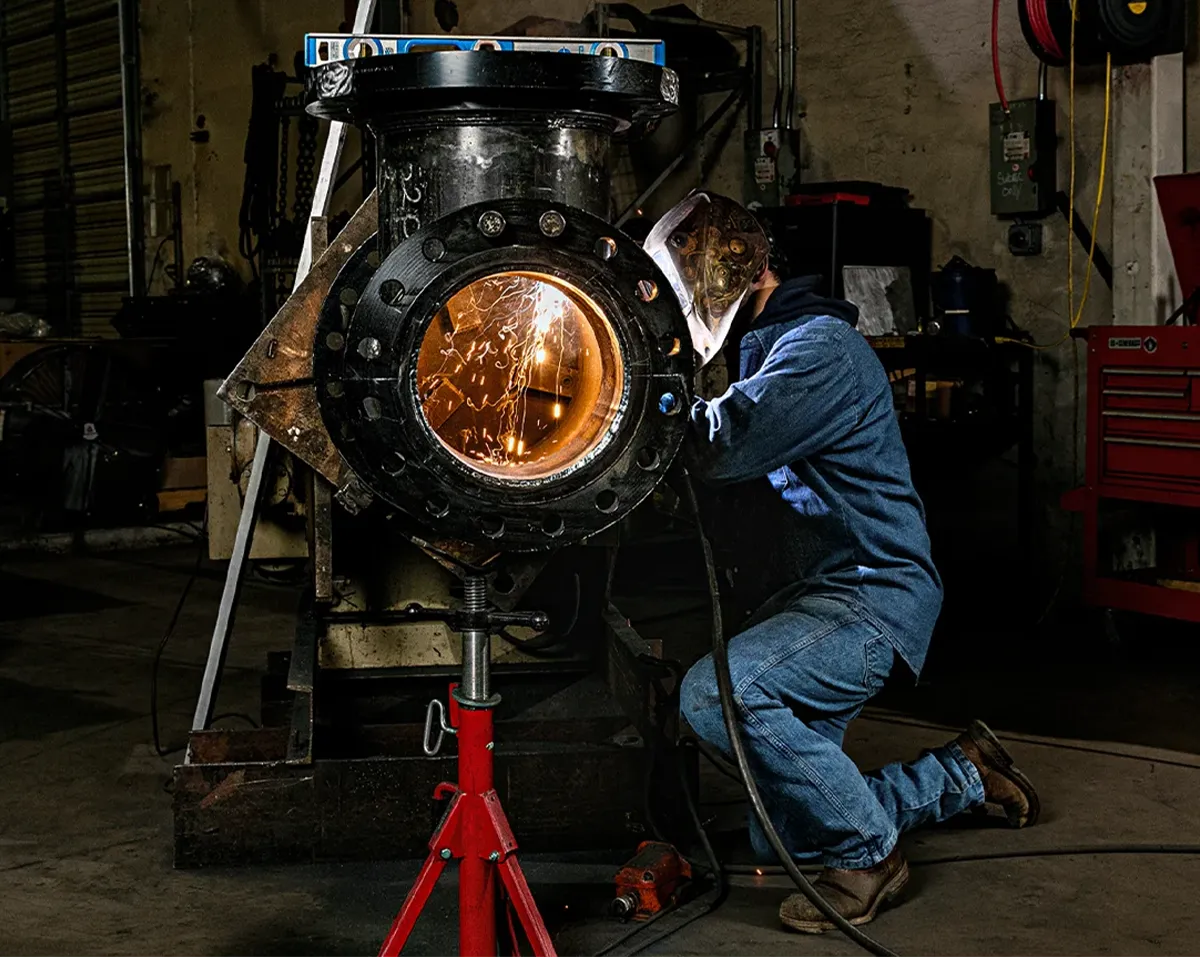 Welder working on industrial equipment during a commercial photography session for American Wheatley.