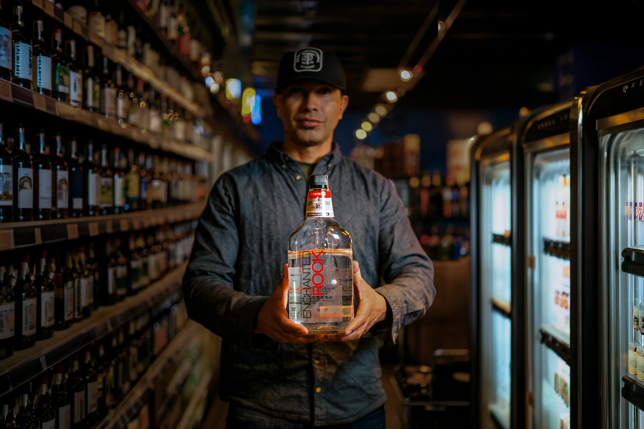 Joe, owner of Milagro, holding a bottle inside his liquor store in San Angelo, Texas.