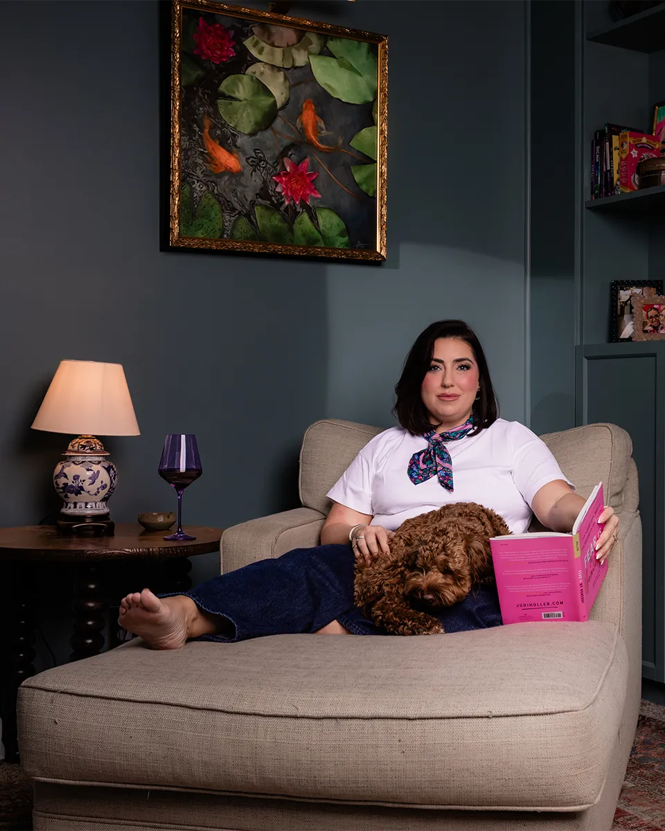 Tulsa Realtor and interior designer May West seated with her dog in a thoughtfully designed interior.
