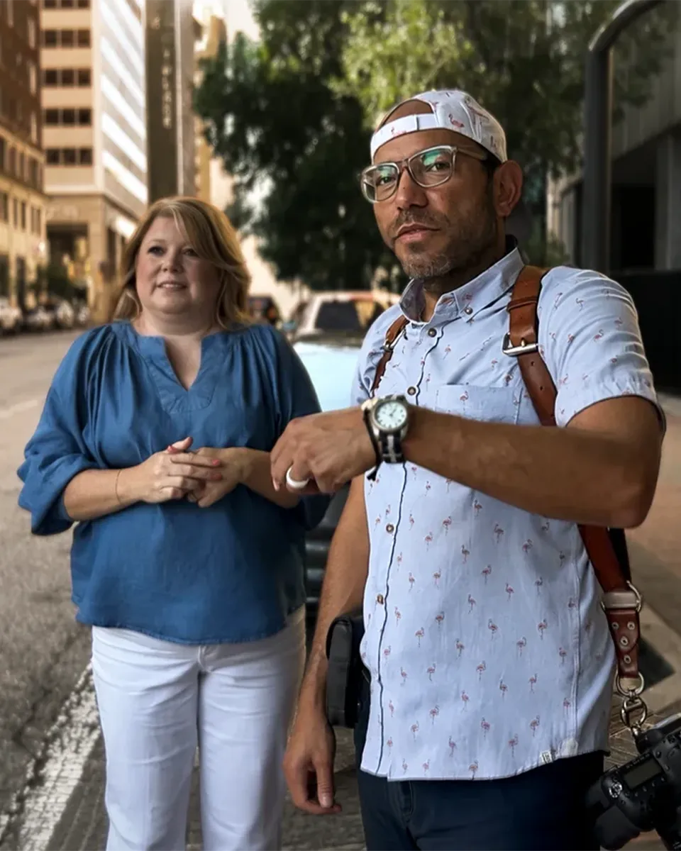 Photographer speaking with a client on a downtown Tulsa street during a location portrait session.